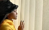 Une jeune femme en pleine quarantaine à Londres positive au Covid regarde par la fenêtre