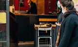 un couple passe devant un bar ouvert, à Barcelone