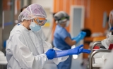 un chirurgien de l'hospital clinic, à Barcelone, enfile ses gants avant une opération