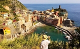 un homme en chapeau en vacances dans un village devant la mer en Italie