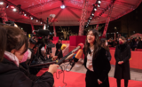 Charlotte Gainsbourg répondant à une interview sous un chapiteau rouge