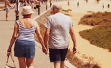Une femme et un homme ages en train de marcher et de se tenir par la main