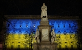 statue de leonardo da vinci et bâtiment illuminé en jaune et bleu