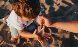 Petit enfant joue avec du sable