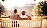 couple marié assis sur un banc devant une maison