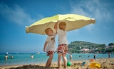 deux enfants sous un parasol jaune a la plage d'alicante