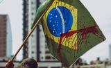 Un manifestant brandit un drapeau du Brésil avec su sang dans les rues de Rio 