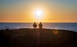 Deux personnes âgées retraitées  regardent le coucher du soleil en Australie 