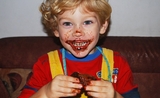 Petit garçon bouche pleine de chocolat