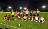 Une équipe de foot amateur à hong kong pose dans un stade la nuit 