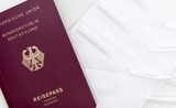 Photo d'un passeport allemand posé sur des masques de protection 