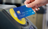 Une personne payant en sans contact avec sa carte bancaire dans les transports en commun à Londres