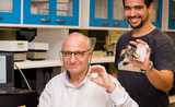 NTU Prof Rachid Yazami left holding his smart battery chip with research fellow Sohaib El Outmani holding a prototype testing device