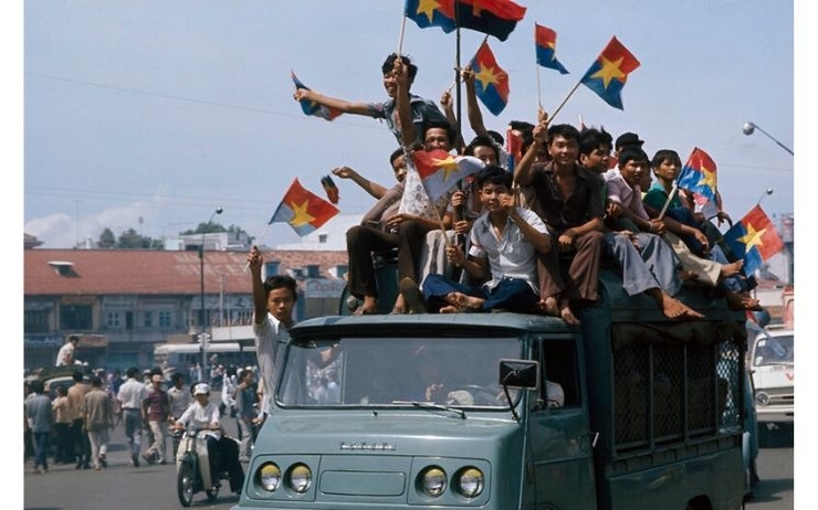 Des Vietnamiens brandissent le drapeau du Front national de libération du Sud-Vietnam