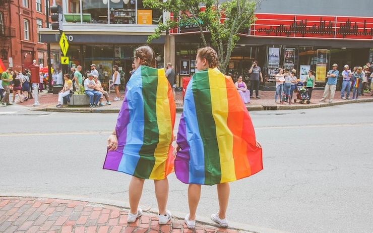 Deux personnes avec le drapeau arc-en-ciel des communautés LGBT