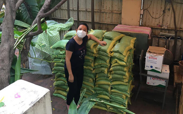 Claire devant des sacs de riz recoltés