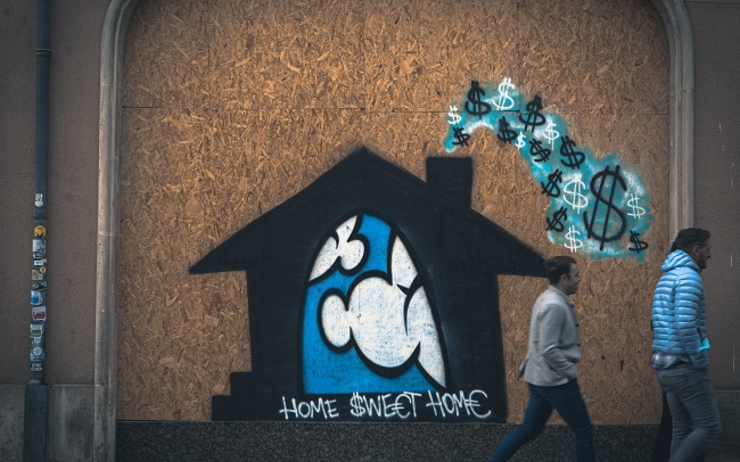 des passants marchent devant le grafiti d'une maison