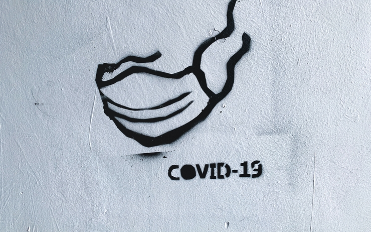 Un graffiti représentant un masque et l'inscription Covid-19