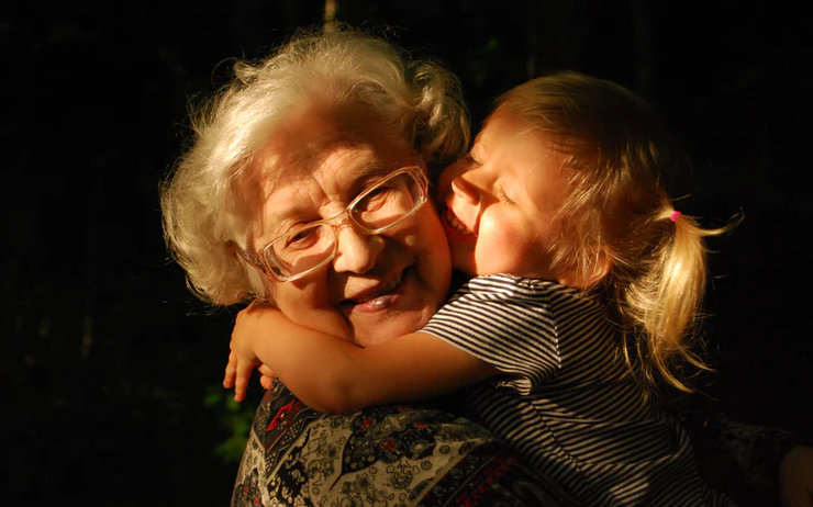 Une petite fille embrasse sa grand-mère 