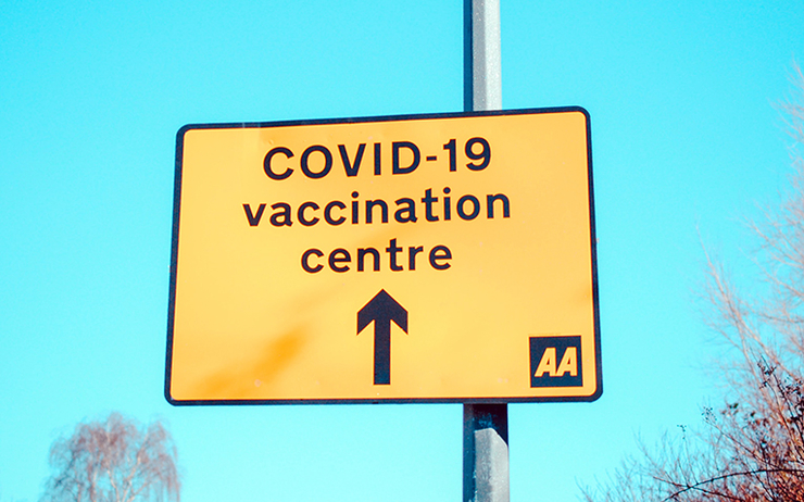 Un panneau qui indique la direction à suite pour aller au centre de vaccination contre la covid-19