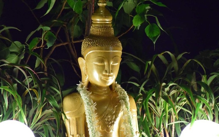 Une statue de Bouddha décorée d'une guirlande de fleurs pour Buddha Purnima