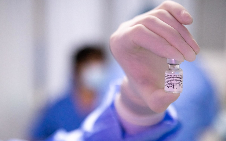 une personne tient une fiole de vaccin contre le covid