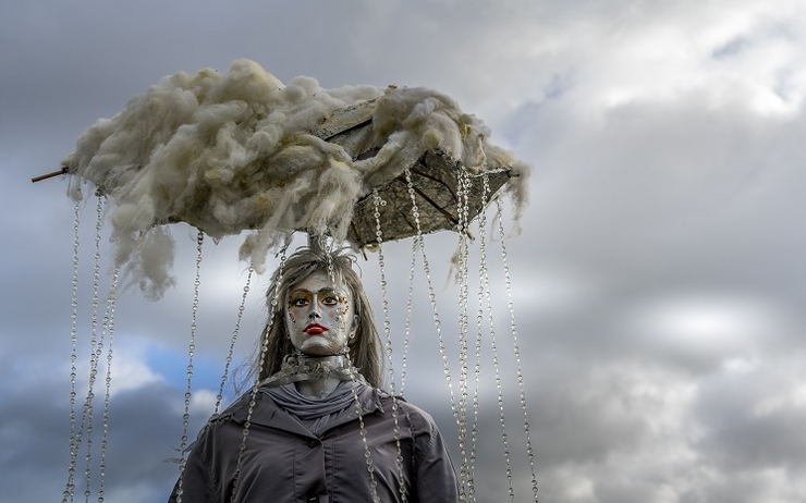 Une sculpture artistique représentant une femme avec un nuage de pluie accroché au-dessus de sa tête