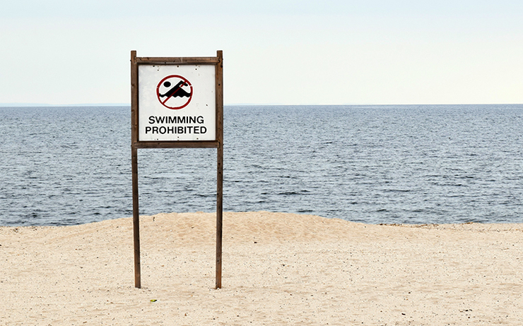 Un panneau baignade interdite sur une plage 