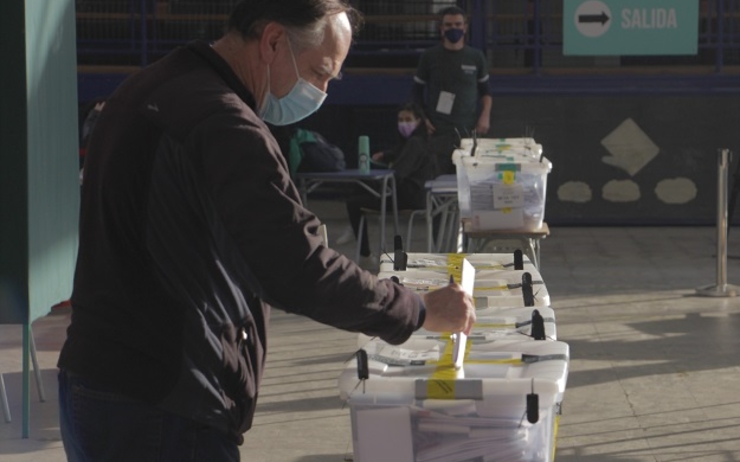 un homme depose son vote dans une urne au chili