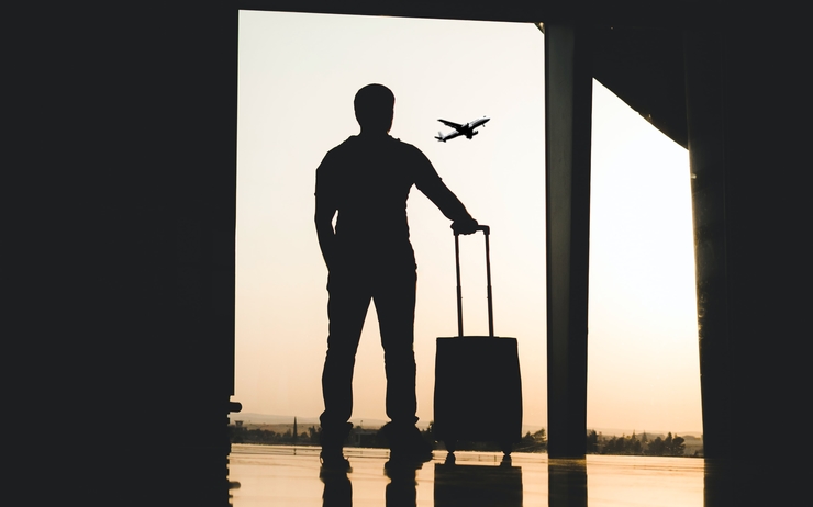 Un expatrié dans un aéroport avec sa valise 