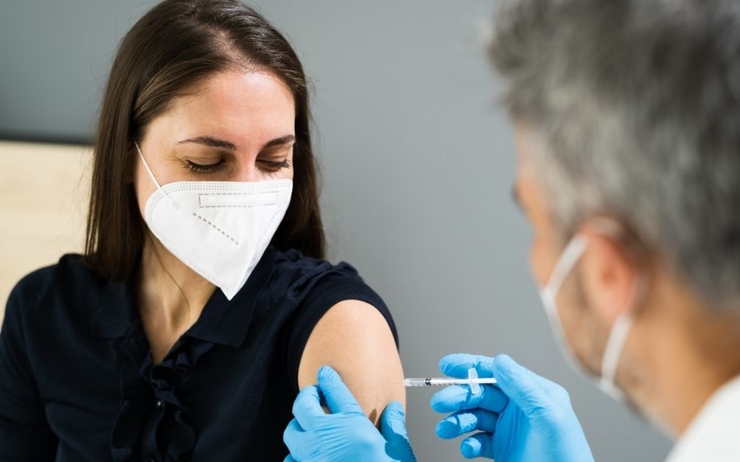 Un médecin 'apprête à vacciner une femme contre la Covid-19