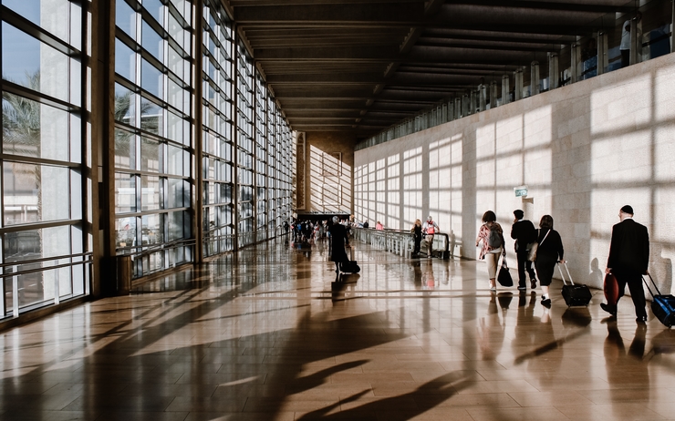 Des passagers avec leur valise marchent dans un aéroport