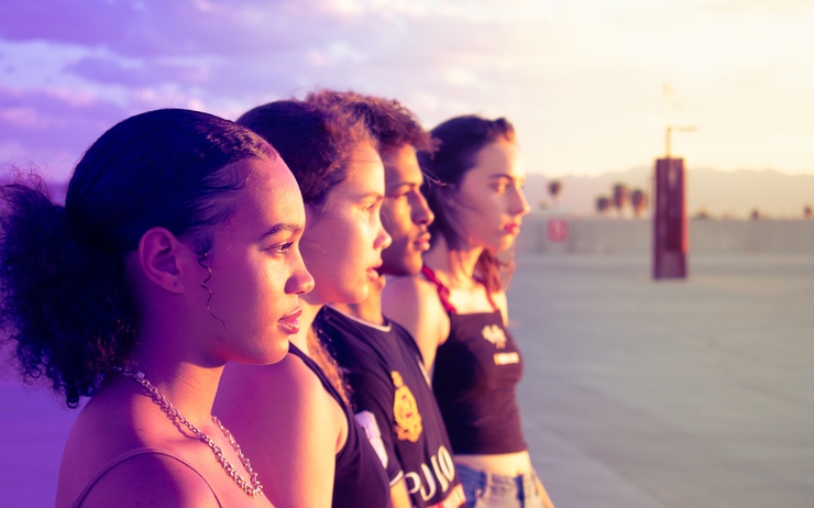 quatre jeunes personnes regardent ensemble vers l'horizon 