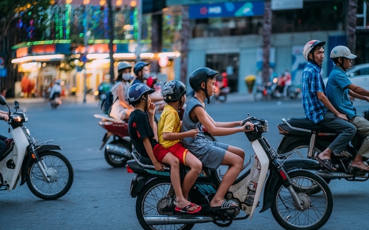 Des adolescents sur un scooter qui vont dans un centre de vaccination au Vietnam