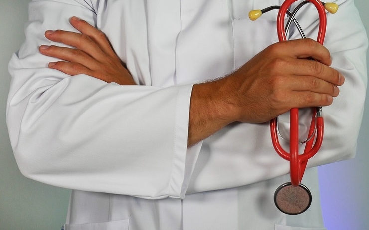 Un docteur homme tient un stéthoscope dans sa main