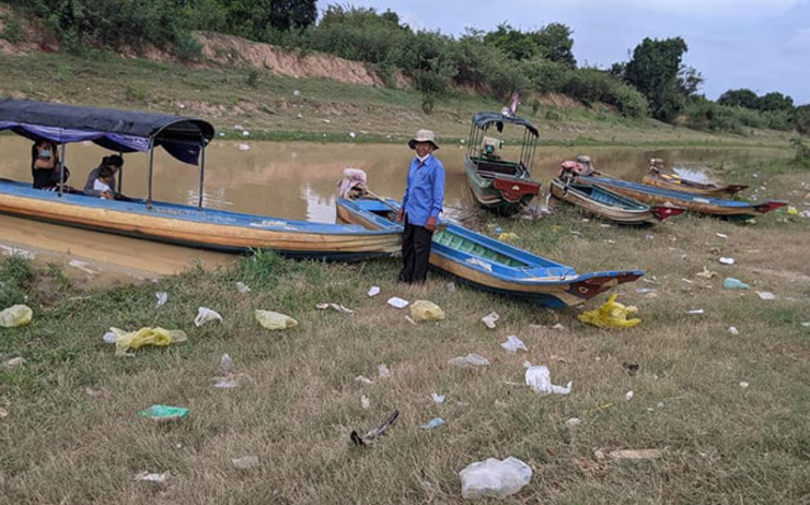 des villageois cambodgiens prés d'un bateau sur les rives du lac