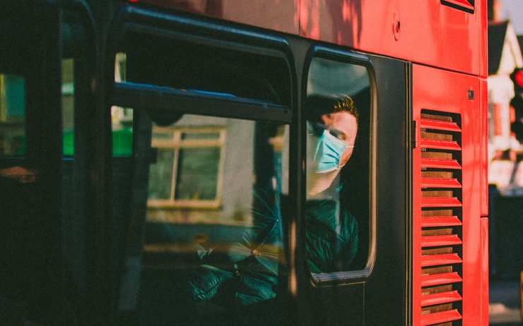 Une personne portant un masque dans un bus londonien