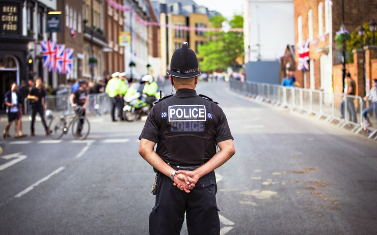 Un policier anglais de dos dans une rue