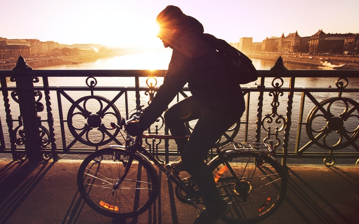 Un homme traverse un pont à vélo.