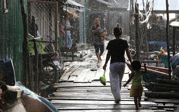 Cambodia_Mother-and-daughther-walk-hand-in-hand-in-the-ran_2013-photo-Karl-Grobl