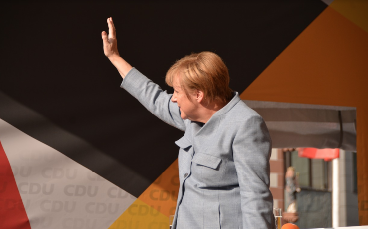 Angela Merkel faisant un signe de la main.
