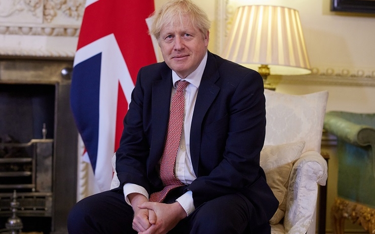 Une photo de Boris Johnson, assis et tout sourire