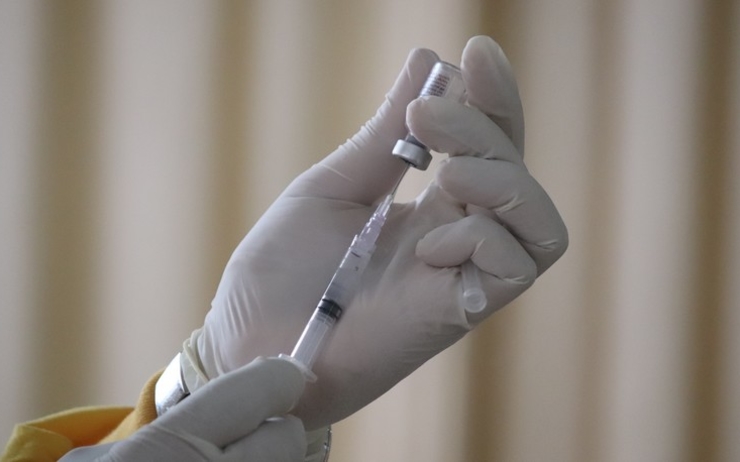 une personne tient un vaccin contre le covid-19 dans sa main