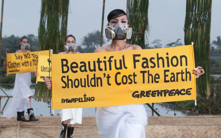 Un défilé de mode avec des pancartes avec messages pour l'environnement