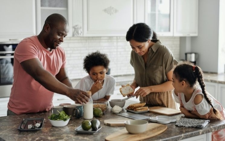 Une famille de quatre préparant à manger dans la cuisine