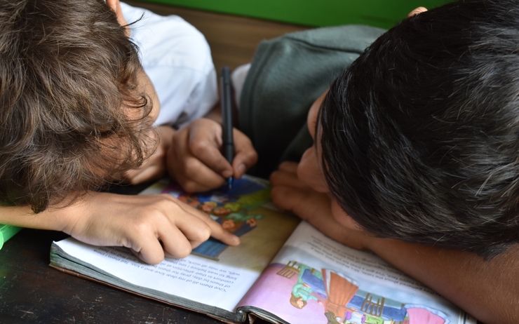 Deux écoliers lisant un livre