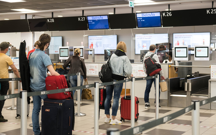 Personnes attendant leur check-in à l'aéroport BER