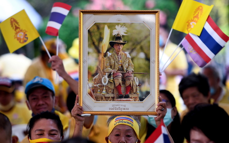 Des thaïlandais défilent avec un portrait du roi