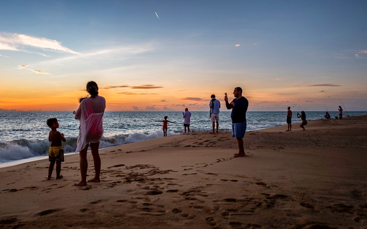 Des Touristes sur une plage de Thailande au coucher du soleil