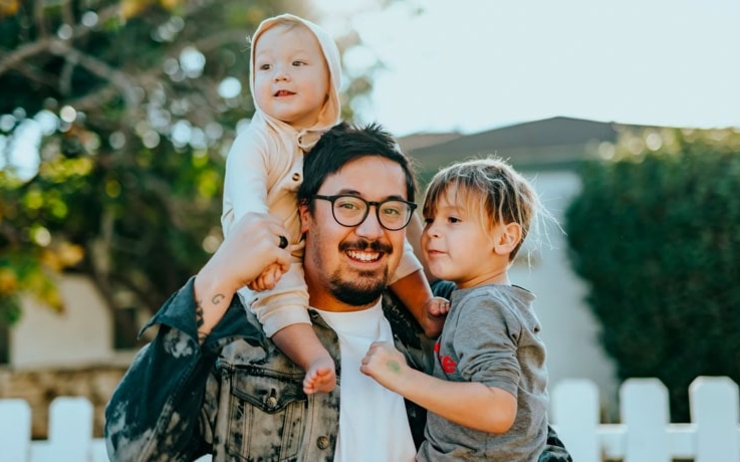 un père et ses enfants devant leur nouvelle maison